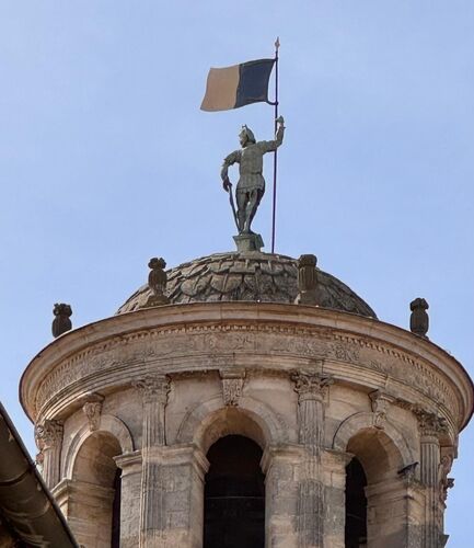The Bronze Man on top of the clock tower. It depicts Mars. Flag pole turns and it is a weathervane (1555)